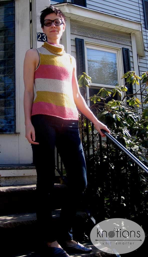 Woman wearing a sleeveless striped tunic with a mock turtleneck