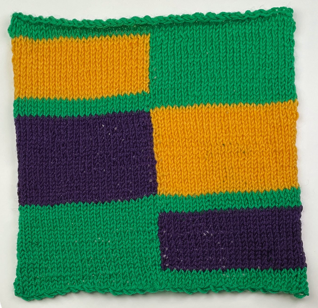 Crop Rotation knit intarsia square in Christmas Green, Italian Plum, and Golden Yellow, with color blocks that trade sides between green bands