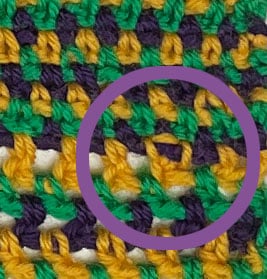Wrong side of the Seed Drill crochet square, with one hdc2tog from the transition row circled in purple