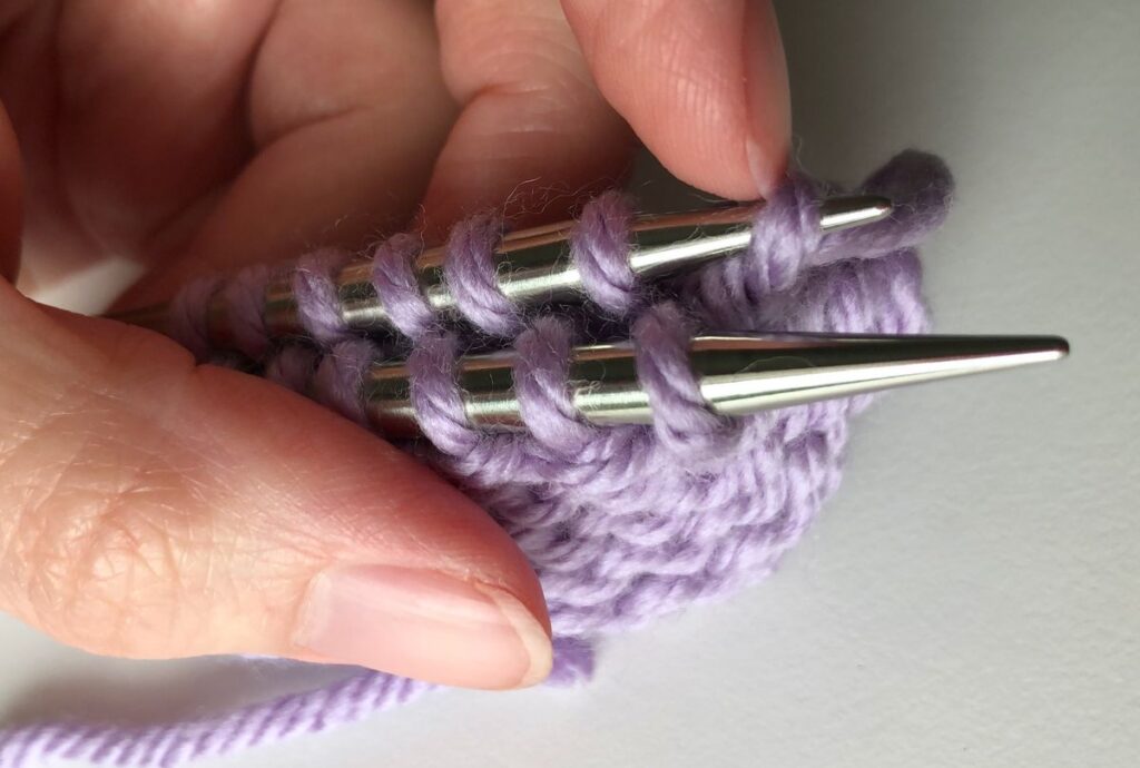 Pushing the first stitch off the back needle in step 1 of the Finchley Graft